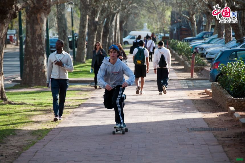 One student at Stellenbosch Univeristy practises the skateboard at the sidewalk after school hours. [Maverick Chen / China.org.cn]