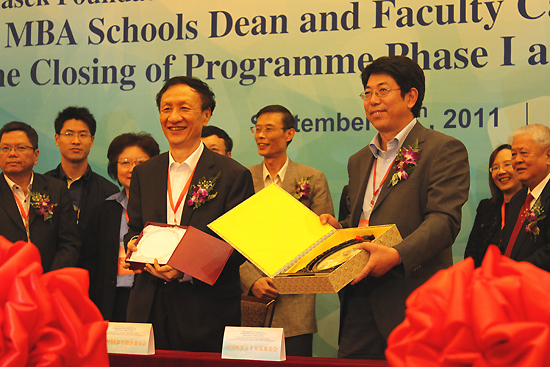 China National MBA Education Supervisory Committee exchanges gifts with Western China Human Resources Development Foundation at the launching ceremony of the China MBA Schools Dean and Faculty Capacity Building Program Phase Ⅱ in Beijing on September 29, 2011. [Photo by Xu Lin / China.org.cn]