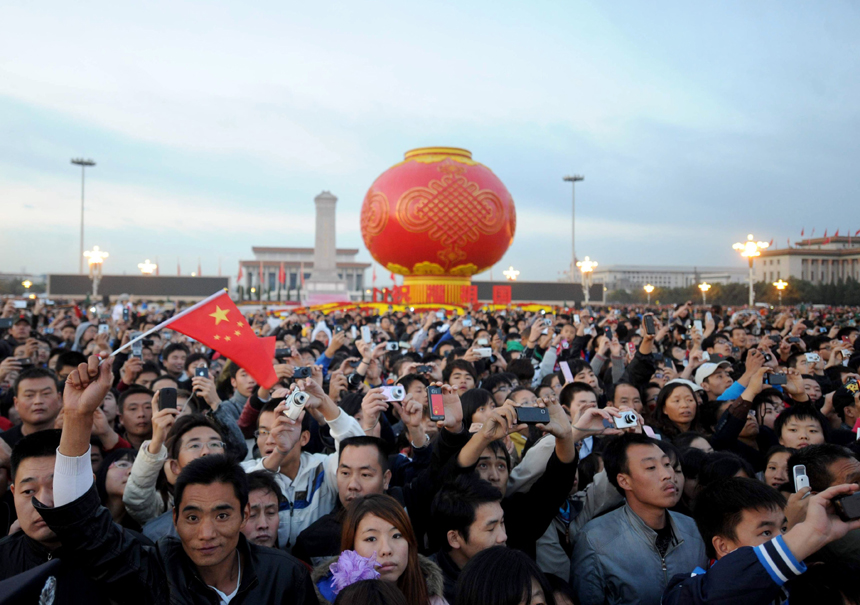 People watch the national flag raising ceremony at the Tian&apos;anmen Square in Beijing, capital of China, Oct. 1, 2011. More than 120,000 people gathered at the Tian&apos;anmen Square to watch the national flag raising ceremony at dawn on Oct. 1, in celebration of the 62nd anniversary of the founding of the People&apos;s Republic of China.