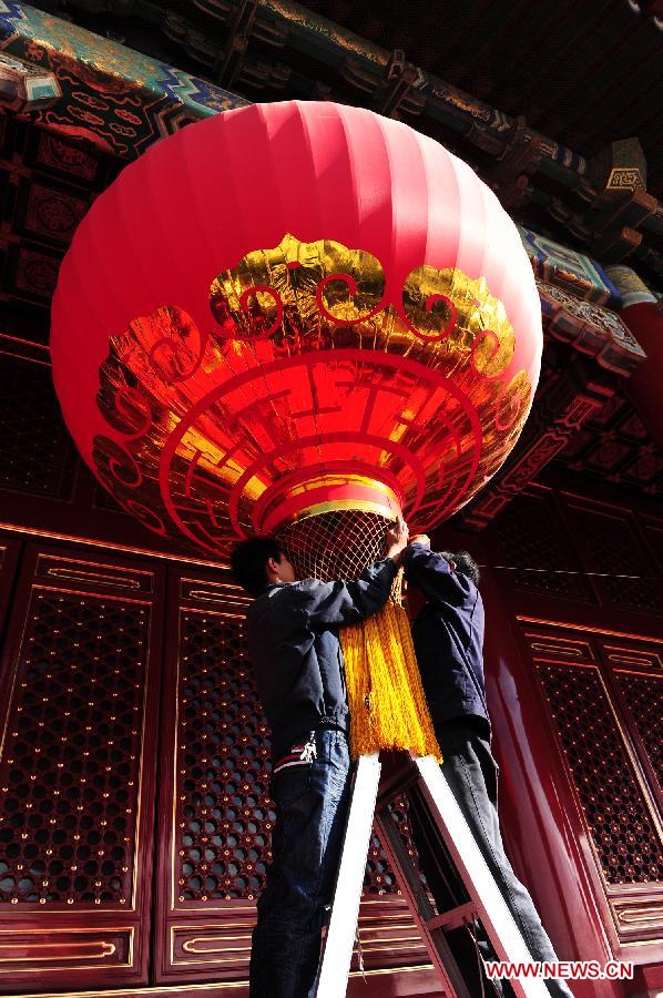 A staff hangs up a big lantern on the Tian&apos;anmen Rostrum in Beijing, capital of China, to celebrate the upcoming National Day on Oct. 1.