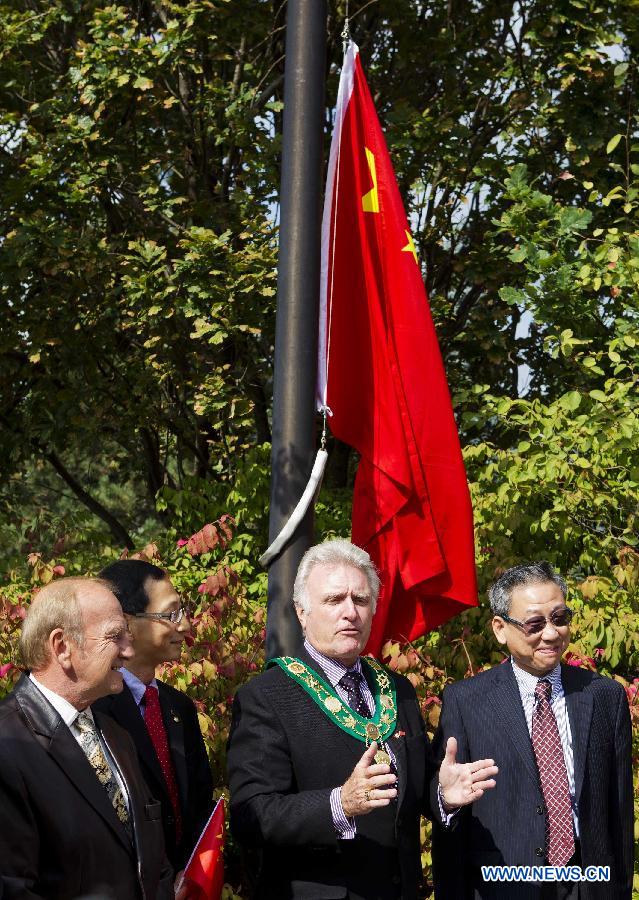 The Consul General of China in Toronto Chen Ligang (1st R) and Mayor of Pickering David Ryan (2nd R) attend the Chinese national flag raising ceremony to celebrate the 62nd anniversary of the founding of the People's Republic of China, in Canadian city of Pickering on Sept. 30, 2011.
