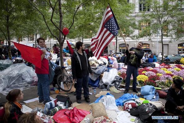 A protestor demonstrate an inverted U.S. flag near Wall Street in New York, the United States, Oct. 2, 2011. [Fan Xia/Xinhua]