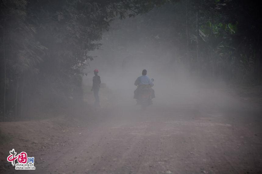 In most rural parts of Tanzania, road conditions are still very poor. Whenever a vehicle passes by, dust will fly, blocking the views of following vehicles and the pedestrians as well. [Maverick Chen / China.org.cn]