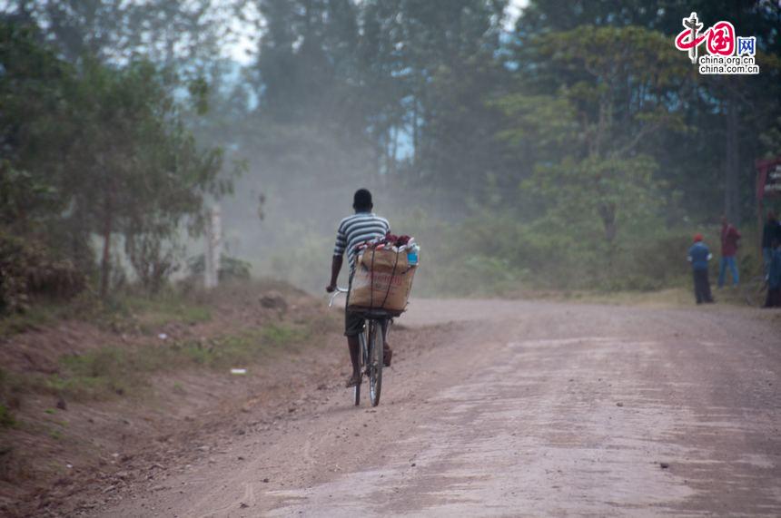 A man peddals his way on a out-of-maintenance village road in Tanzania. [Maverick Chen / China.org.cn]