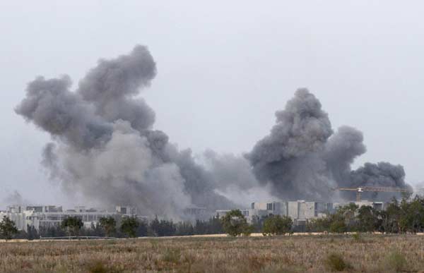 Heavy smoke rises from Sirte city after NATO bombing of the positions of Gadhafi loyalists during heavy fighting with anti-Gadhafi forces, as they push forward towards the centre of Sirte October 7, 2011. [Agencies]