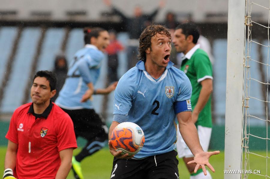 Uruguay's Diego Lugano (R) celebrates scoring against Bolivia during a qualifying match for the 2014 World Cup in Montevideo, capital of Uruguay, on Oct. 7, 2011.Uruguay beat Bolivia 4-2. [Nicolas Celaya/Xinhua]