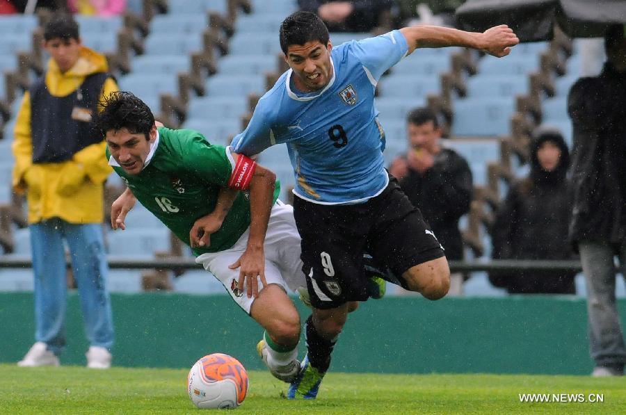 Uruguay's Luis Suarez (R) vies with Bolivia's Ronald Raldes during a qualifying match for the 2014 World Cup in Montevideo, capital of Uruguay, on Oct. 7, 2011.Uruguay beat Bolivia 4-2. [Nicolas Celaya/Xinhua]