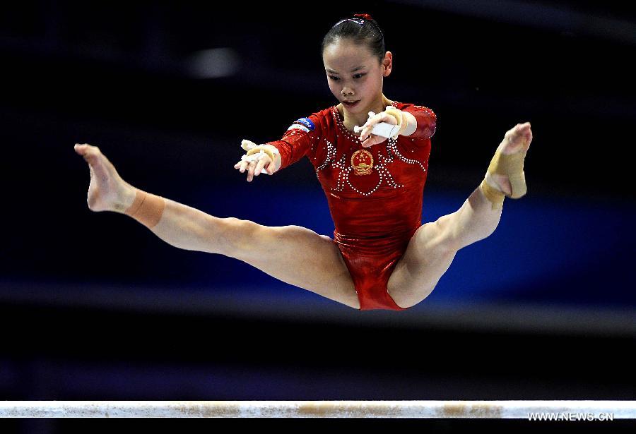 China's Tan Sixin competes on the uneven bars during the women's team qualifying round of the World Gymnastics Championships in Tokyo, capital of Japan, on Oct. 8, 2011. [Chen Xiaowei/Xinhua]