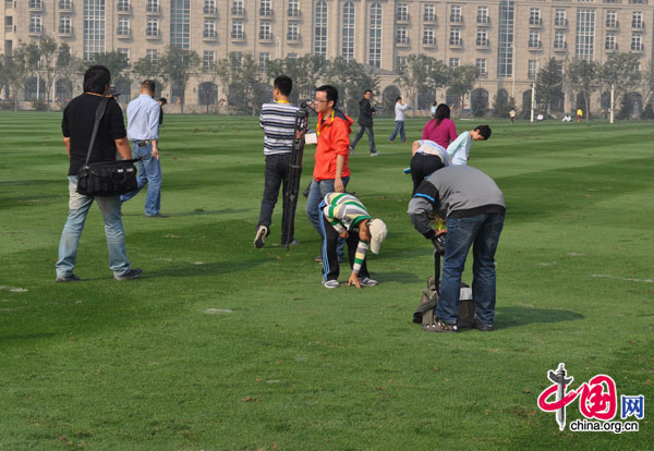 A youngster tends to the turf during the traditional half-time polo tradition of 'Stomping the divots' at the Goldin U18 International Tournament in Tianjin , Oct 5.