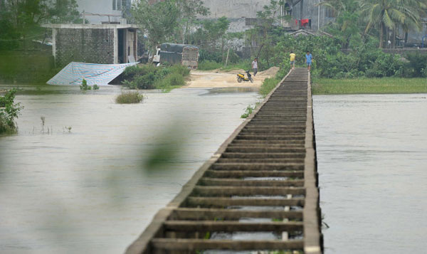 A road in a village of Longquan town in Haikou, Hainan province is submerged in flood water after days of heavy rains on Oct 8, 2011. [Xinhua] 