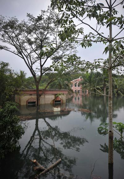 Houses beside a express way near Haikou, Hainan province are seen submerged in flood water after days of heavy rains on Oct 8, 2011. 