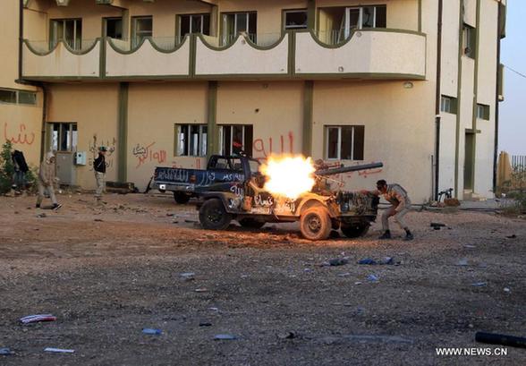 Soldiers of Libya's National Transitional Council (NTC) fire at Gaddafi loyalists in Bani Walid, Libya, Oct. 9, 2011. The head of the ruling Libyan National Transitional Council (NTC) Mustafa Abdel-Jalil said Sunday that it is possible to end the battles next week in Bani Walid and Sirte, the only remaining strongholds of fallen leader Muammar Gaddafi. [Hamza Turkia/Xinhua] 