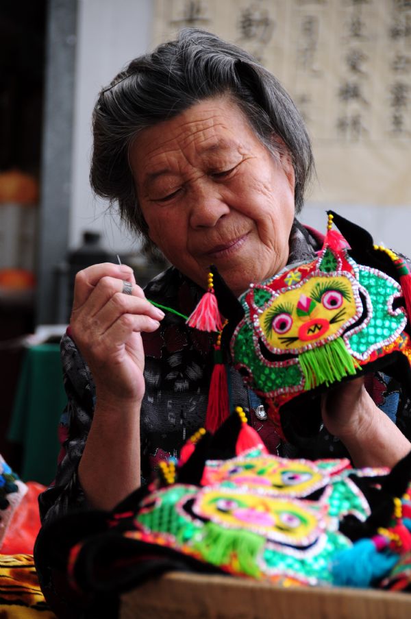 Gao Qinying works on a tiger hat in Tancheng County of Linyi City in east China's Shandong Province, Oct. 5, 2011. 