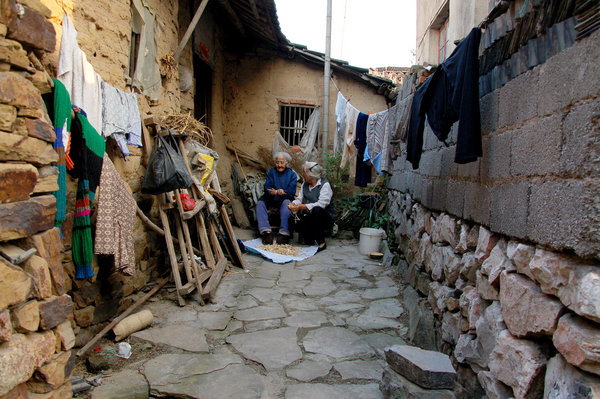 Tao and her mother-in-law pick beans in the yard of their house in Zhu village, Chaohu city in East China's Anhui province, Oct 9, 2011. [Photo/CFP]