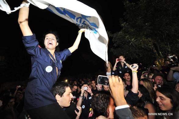 Supporters of captured Israeli soldier Gilad Shalit celebrate outside the residence of Israel's Prime Minister Benjamin Netanyahu in Jerusalem on Oct. 11, 2011. Israeli Prime Minister Benjamin Netanyahu said Tuesday that Israel has reached a prisoner swap deal with the Islamic Hamas Movement and Israeli soldier Gilad Shalit held captive by Hamas will be 'coming home' in a couple of days. [Yin Dongxun/Xinhua] 