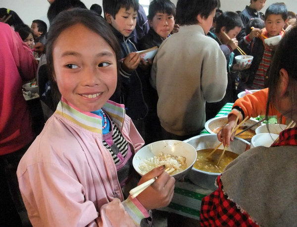 Students at Xinhai primary school in Zhaoyang district of Zhaotong, a city in Yunan province, have lunch in the school canteen on Sept 26, 2011. A nutritious breakfast project run by NGOs is donating food to the students. [Cheng Yinqi / China Daily]