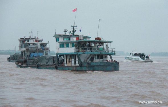  Chinese sailors and their family members, who were stranded in northern Thailand after two ships were attacked last week, start to return to China from Chiang Saen port, Thailand, on Oct. 14, 2011. [Yang Dingdu/Xinhua]