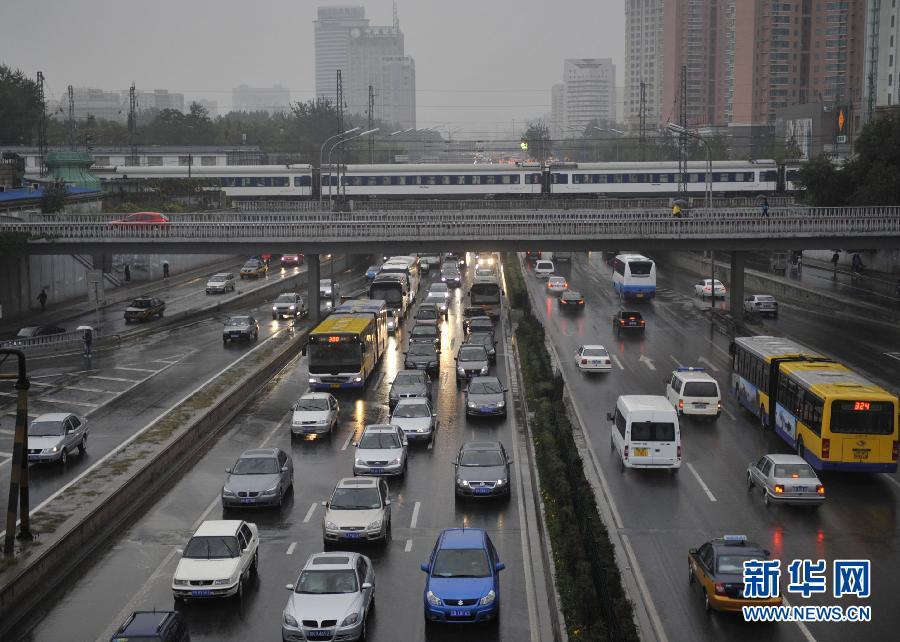 Vehicles move in the rain on the Third Ring Road in Beijing, Oct. 13, 2011. Temparature dropped as Beijing embraced a rainfall on Thursday. 