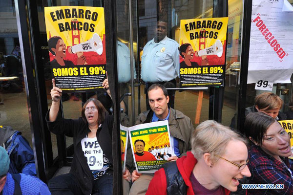 Protestors demonstrate in front of Wells Fargo Bank in San Francisco, the U.S., on Oct. 12, 2011. Hundreds of protestors attended the demonstration here on Wednesday to respond the Occupy Wall Street protest and to protest against the high umemployment rate and the wide gap between the rich and the poor. [Liu Yilin/Xinhua]