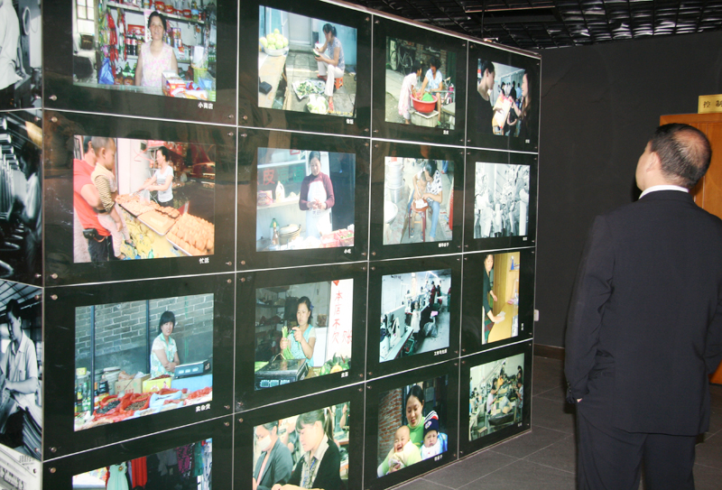 An audience watches display board about female migrant workers. [CnDG by Jiao Meng]