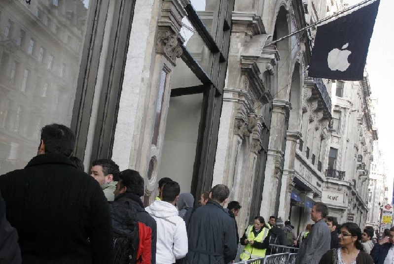 Apple fans queue to buy iPhone 4S mobile phones at the Apple Store on Regents Street in central London, Britain, Oct. 14, 2011. Apple's new mobile phone iPhone 4S went on sale in US, UK, Australia, Canada, France, Germany and Japan on Oct. 14.