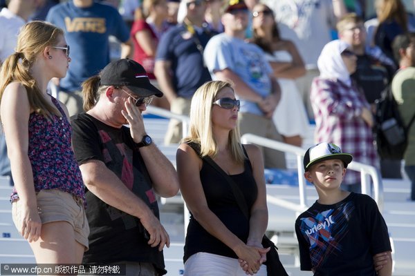 Fans stand as drivers take five tribute laps in honor of Dan Wheldon, a two-time Indianapolis 500 winner who died following a crash during IndyCar Series' Las Vegas Indy 300 Auto Race at Las Vegas motor speedway in on Sunday, Oct. 16, 2011.