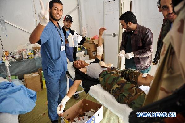 A Libyan National Transitional Council (NTC) fighter receives medical treatment at a front line hospital in the suburbs of Bani Walid, Libya, Oct. 17, 2011. [Li Muzi/Xinhua]