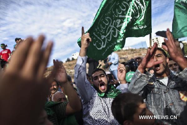 Palestinians celebrate the prisoners swap deal reached between Israel and Hamas outside Ofer prison near the West Bank city of Ramallah on Oct. 18, 2011. Islamic Hamas movement has just handed over an Israeli soldier to Egypt after five years in captivity as Israel started moving Palestinian prisoners who would be exchanged for Corporal Gilad Shalit, sources said Tuesday. [Fadi Arouri/Xinhua]