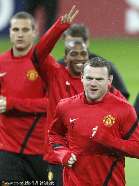 Manchester United's Wayne Rooney (foreground) warms up with team mates during their training session on the eve of their Group C Champions League match against Otelul Galati in Bucharest, Romania on Monday, Oct. 17, 2011.