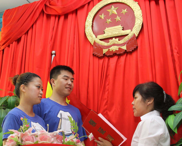  A young couple say their oaths at a marriage registration office in Wuxi city, Jiangsu province. [Chang Lin / for China Daily]