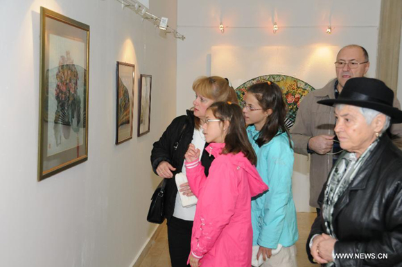 Visitors look at the artworks displayed in an exhibition in the Romanian Peasant Museum in Bucharest, capital of Romania, October 17, 2011. The exhibition 'Art and craftsmanship in China - Umbrellas, Fans and Embroideries' opened on Monday and will show until Nov. 13.