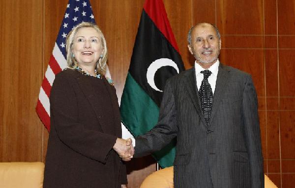 U.S. Secretary of State Hillary Clinton (L) shakes hands with Libya's National Transitional Council (NTC) President Mustafa Abdel Jalil during their meeting at the headquarters of the World Islamic Call Society during a visit to Tripoli October 18, 2011. [Xinhua] 