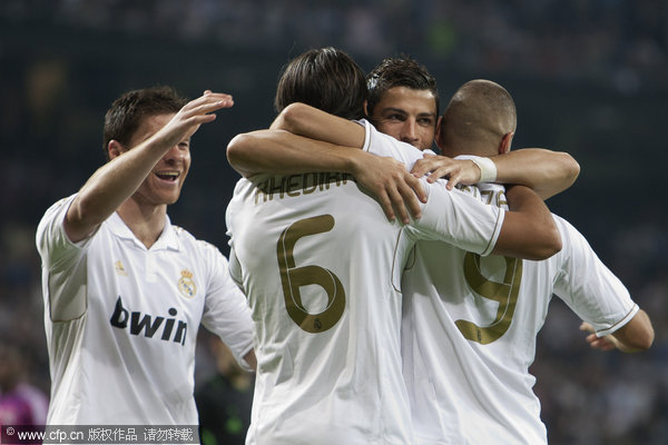Real Madrid's Sami Khedira (2nd left) reacts after scoring against Lyon with fellow team members Xabi Alonso (left), Cristiano Ronaldo (2nd right) and Karim Benzema from France during their Group D champions league soccer match at Santiago Bernabeu stadium in Madrid on Tuesday, Oct. 18, 2011.