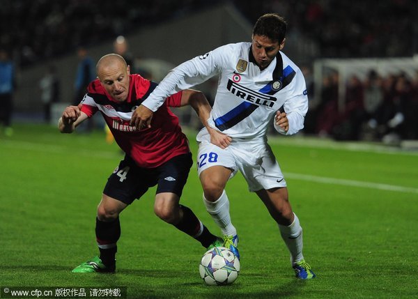 Florent Balmont of LOSC Lille Metropole battles with Mauro Zarate of FC Internazionale Milano during the UEFA Champions League, group B match between LOSC Lille Metropole and FC Internazionale Milano at Stade Lille-Metropole on October 18, 2011 in Lille, France. 
