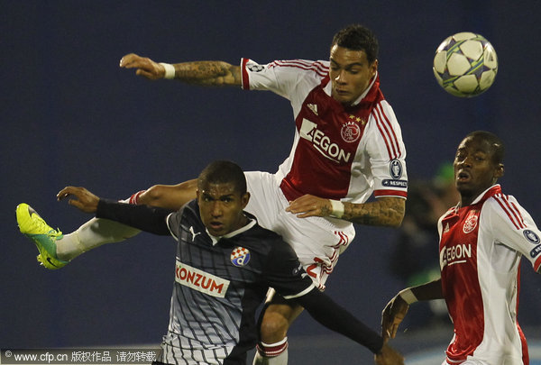 Dinamo Zagreb's Sammir (bottom) is challenged by Gregory van der wiel during their Champions League Group D soccer match at Maksimir stadium in Zagreb, Croatia on Tuesday, Oct. 18, 2011.