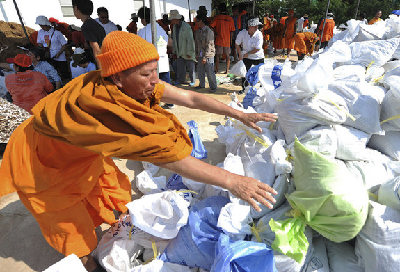 Thai Buddhist monks prepare sandbags to be used as flood barriers at Dhammakaya temple in Pathum Thani province, suburban Bangkok. [Agencies] 