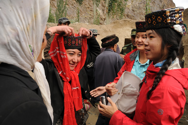 CCTV reporter He Ying (right) talks with local people in Taxcorgan county. [Provided to China Daily] 