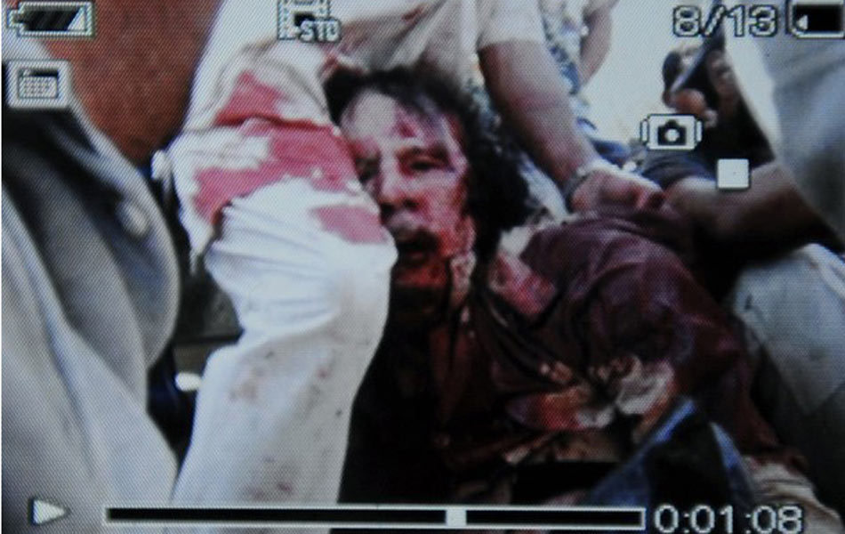 An image captured off a cellular phone camera shows the arrest of Libya&apos;s strongman Muammar Gaddafi in Sirte on October 20, 2011. Libya&apos;s fallen leader Muammar Gaddafi died of wounds in his capture on Thursday in Sirte, after nearly two months on the run, as fighters of the ruling National Transitional Council (NTC) claimed control of Gaddafi&apos;s hometown. [Xinhua] 