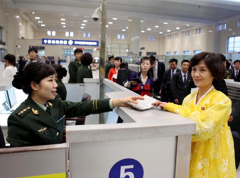 An artist passes through the Dandong frontier inspection station in Dandong, northeast China's Liaoning Province, Oct. 21, 2011. About 180 artists of the Phibada Opera Troupe from the Democratic People's Republic of Korea (DPRK) arrived in China Friday. The troupe will stage opera 'The Butterfly Lovers' in various cities of China in the next 3 months.