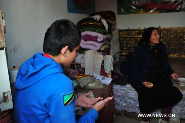 The 18-year-old vagrant boy Weliy (L) and mother of his stepfather are seen at home in Yarkant County, northwest China's Xinjiang Uygur Autonomous Region, Oct. 18, 2011. 