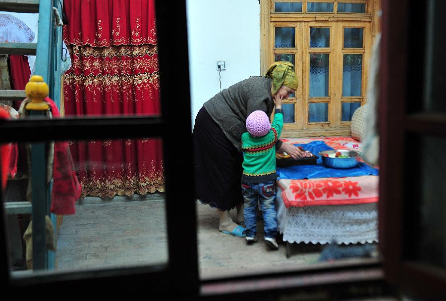 Bulpatman Mamat makes preparation for cooking at her house in the old city zone of Kashgar, northwest China's Xinjiang Uygur Autonomous Region, Oct. 21, 2011.