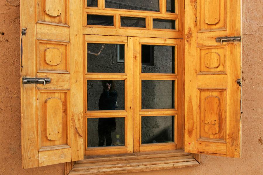 The shadow of a woman is seen on the glass of a wooden window in the old city zone of Kashgar, northwest China's Xinjiang Uygur Autonomous Region, Oct. 21, 2011.
