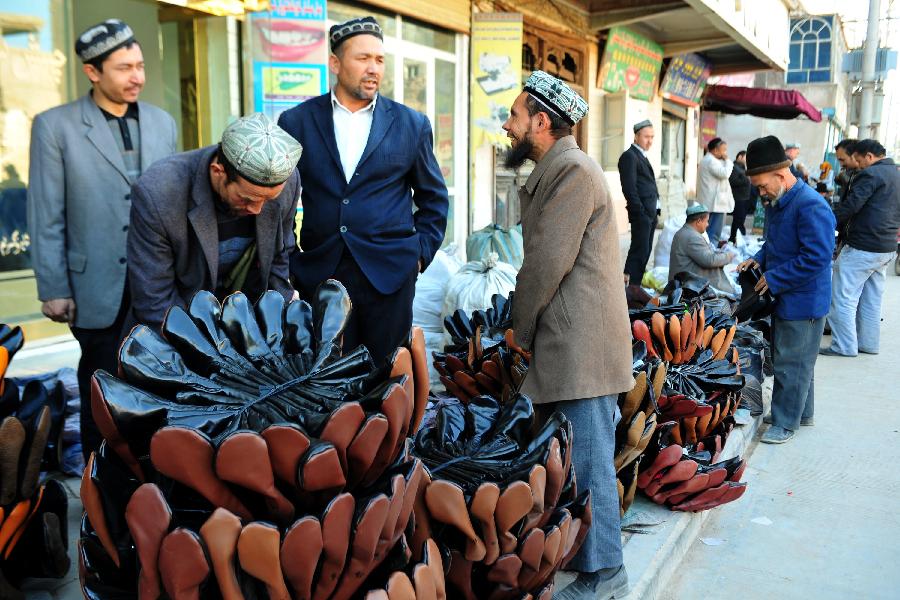 People sell leather stocking in the old city zone of Kashgar, northwest China's Xinjiang Uygur Autonomous Region, Oct. 21, 2011. 