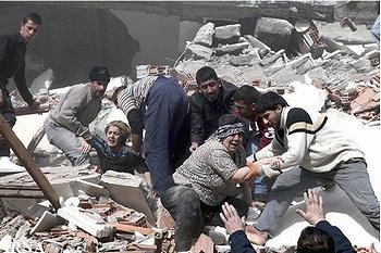 Rescue workers pull injured people from the rubble of collapsed buildings in the city of Van, Turkey