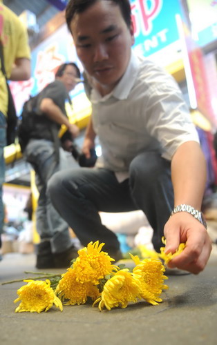 A resident lays flowers on Oct 21 at the site of the accident where 2-year-old Yue Yue was twice hit by vehicles at a hardware market in Foshan, Guangdong province. [Photo/provided to China Daily]