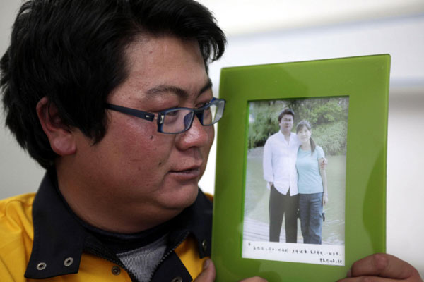 Yu Benfan holds up a photo of him and his wife, taken five years ago, Oct 22, 2011. [Photo/Xinhua]