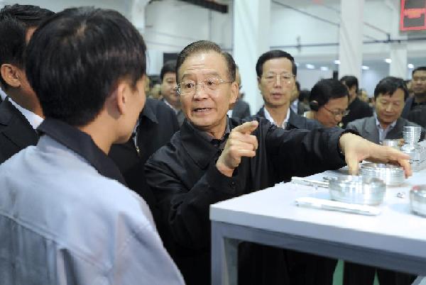 Chinese Premier Wen Jiabao (C), talks with an employee of a vocational skills training center in the Binhai New Area of Tianjin Municipality, north China, Oct. 24, 2011. Wen made a two-day inspection tour in the Binhai New Area of Tianjin on Oct. 24 and 25, during which he held talks with leading officials from Tianjin, Inner Mongolia Autonomous Region and the provinces of Jiangsu and Shandong. [Ma Zhancheng/Xinhua]