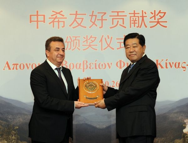 Jia Qinglin (R), chairman of the National Committee of the Chinese People's Political Consultative Conference, honors Crete Governor Stavros Arnaoutakis during an awarding ceremony for those who did great contributions in the evacuation operation of Chinese nationals from Libya through the Greek island of Crete, in Crete Island, Greece, Oct. 26, 2011. (Xinhua/Liu Jiansheng) (xzj) 