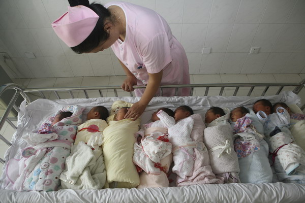 A nurse takes care of newborns at No 1 People's Hospital in Xiangyang, Hubei province. China's family planning policy has slowed the rapid growth of population. [Photo by Gong Bo/Xinhua] 