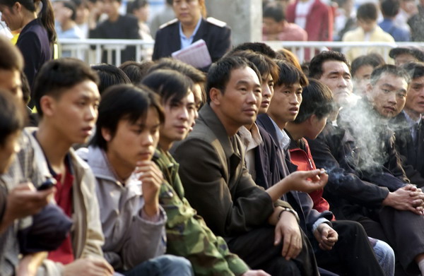 Smoking is not allowed at Guangzhou Railway Station and other government buildings, but it goes on anyway. Enforcement of the year-old regulation is spotty.[Photo/China Daily]